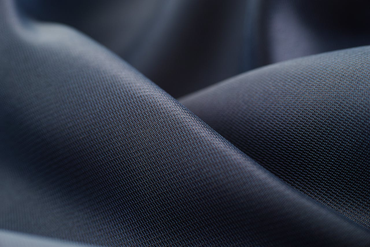 Elegant close-up of smooth, dark satin fabric showcasing texture and sheen.
