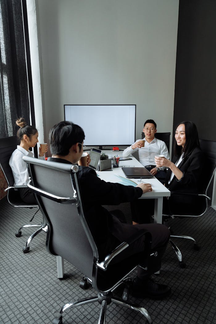 Group of professionals engaged in a collaborative meeting in a modern office setting.